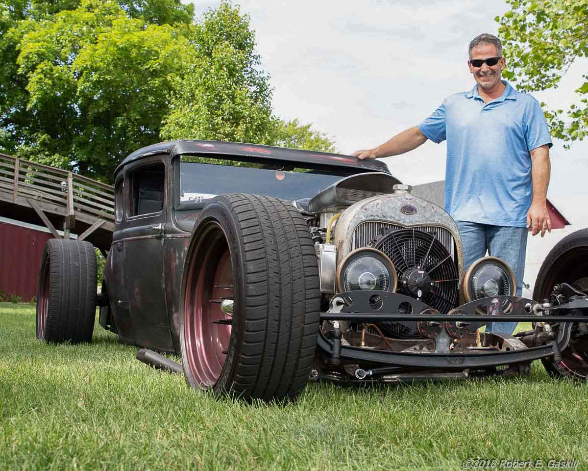 Man standing with an old vehicle