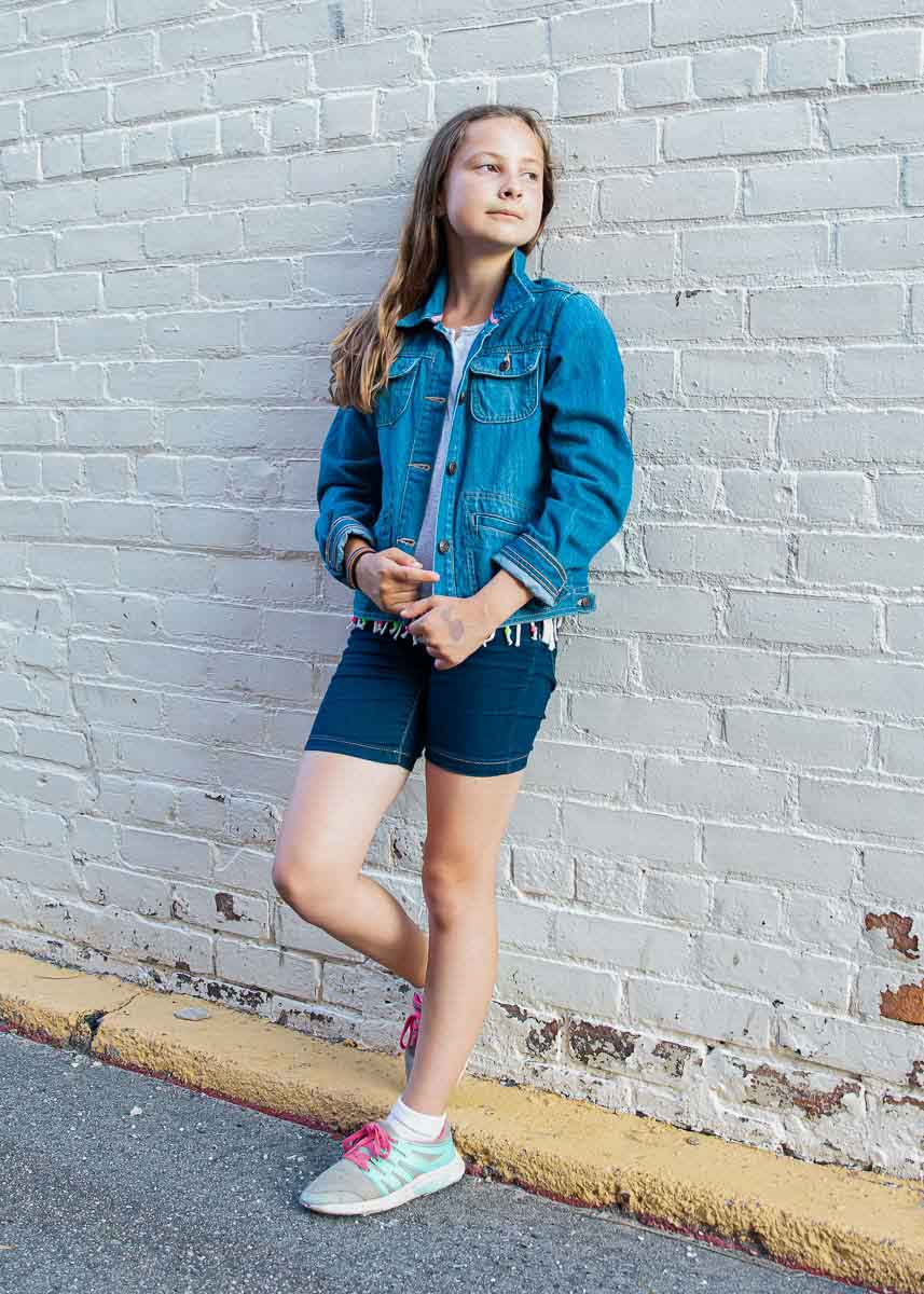 Daughter standing with white wall backdrop
