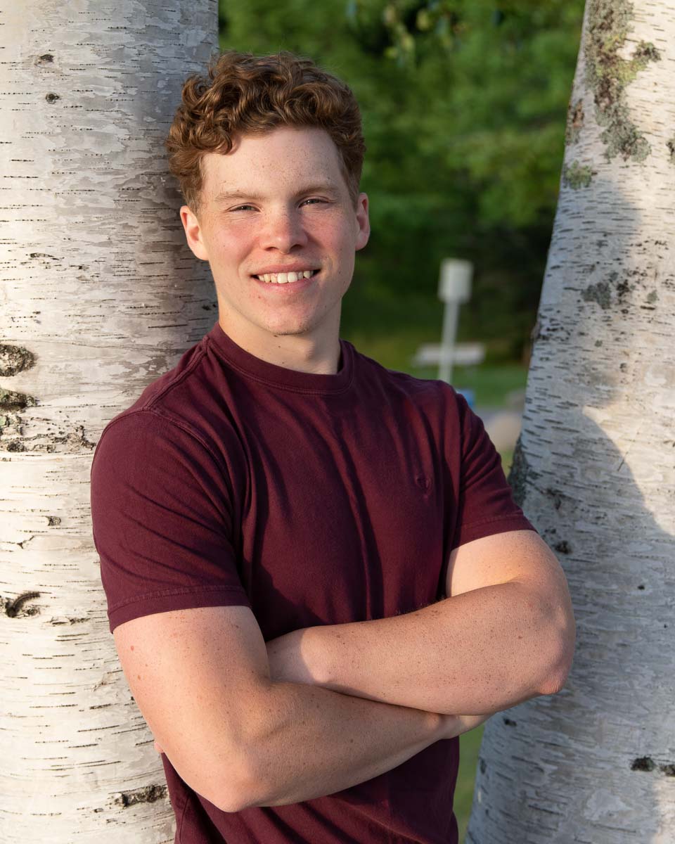 Senior standing between two birch trees