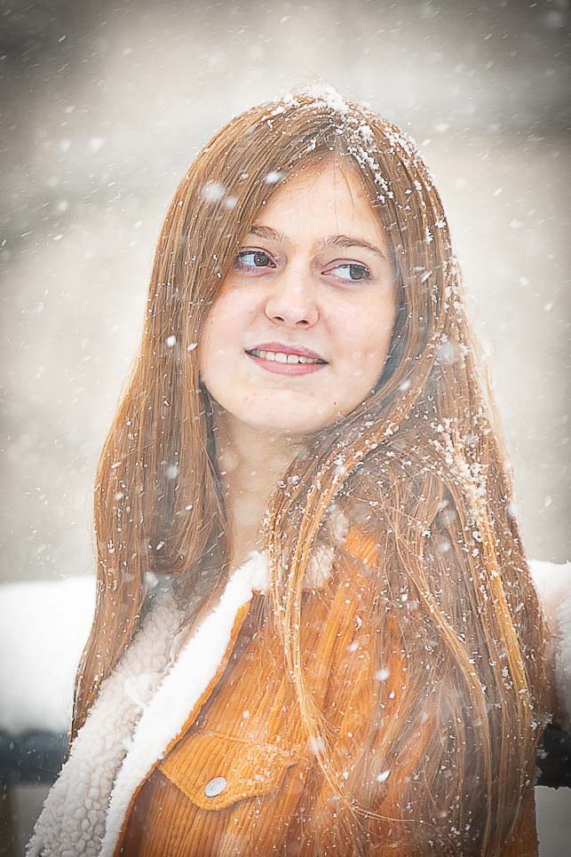 Senior looking into the distance with snowfall