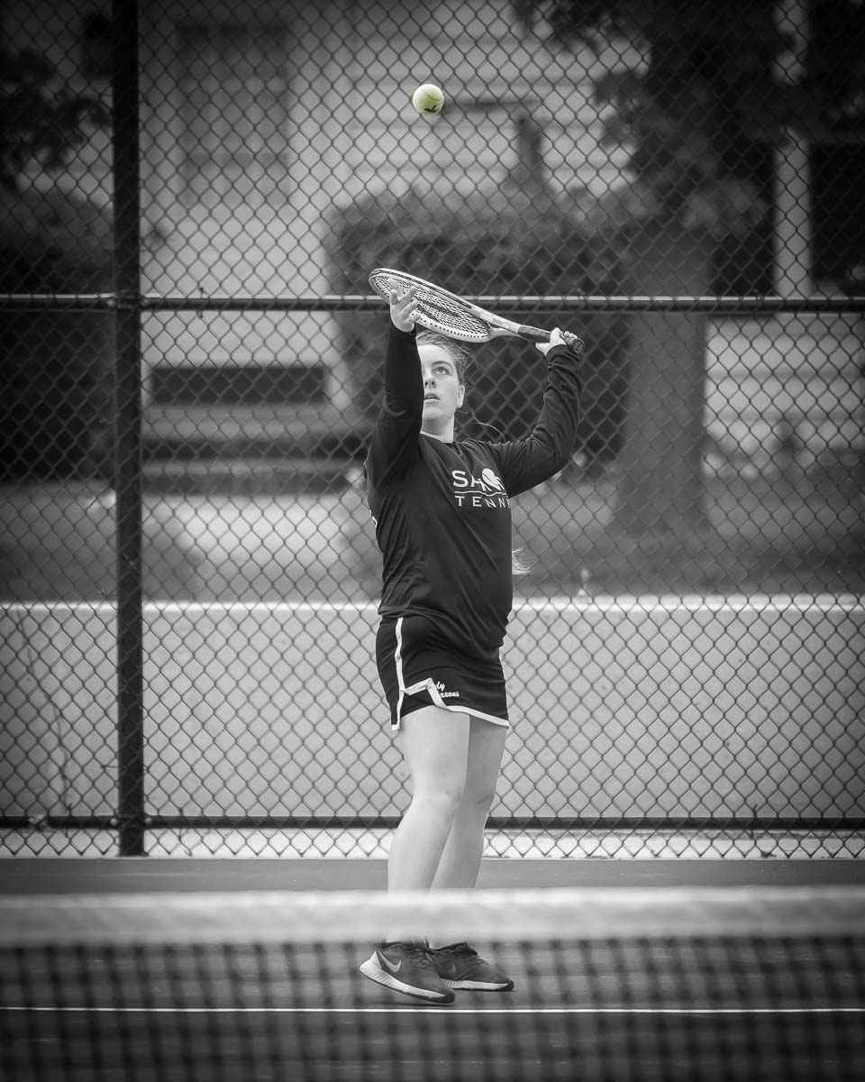 Girl about to strike tennis ball with racket
